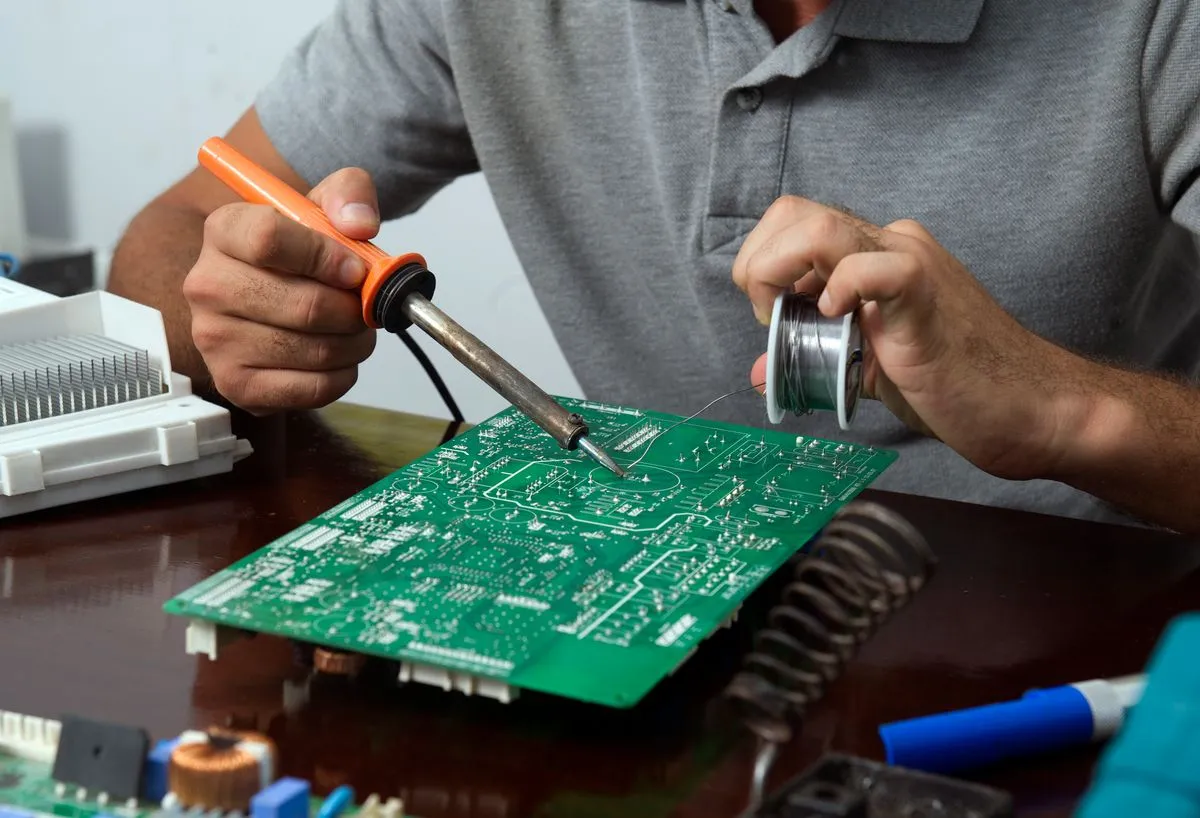 Ingeniero soldando componentes en una placa de control